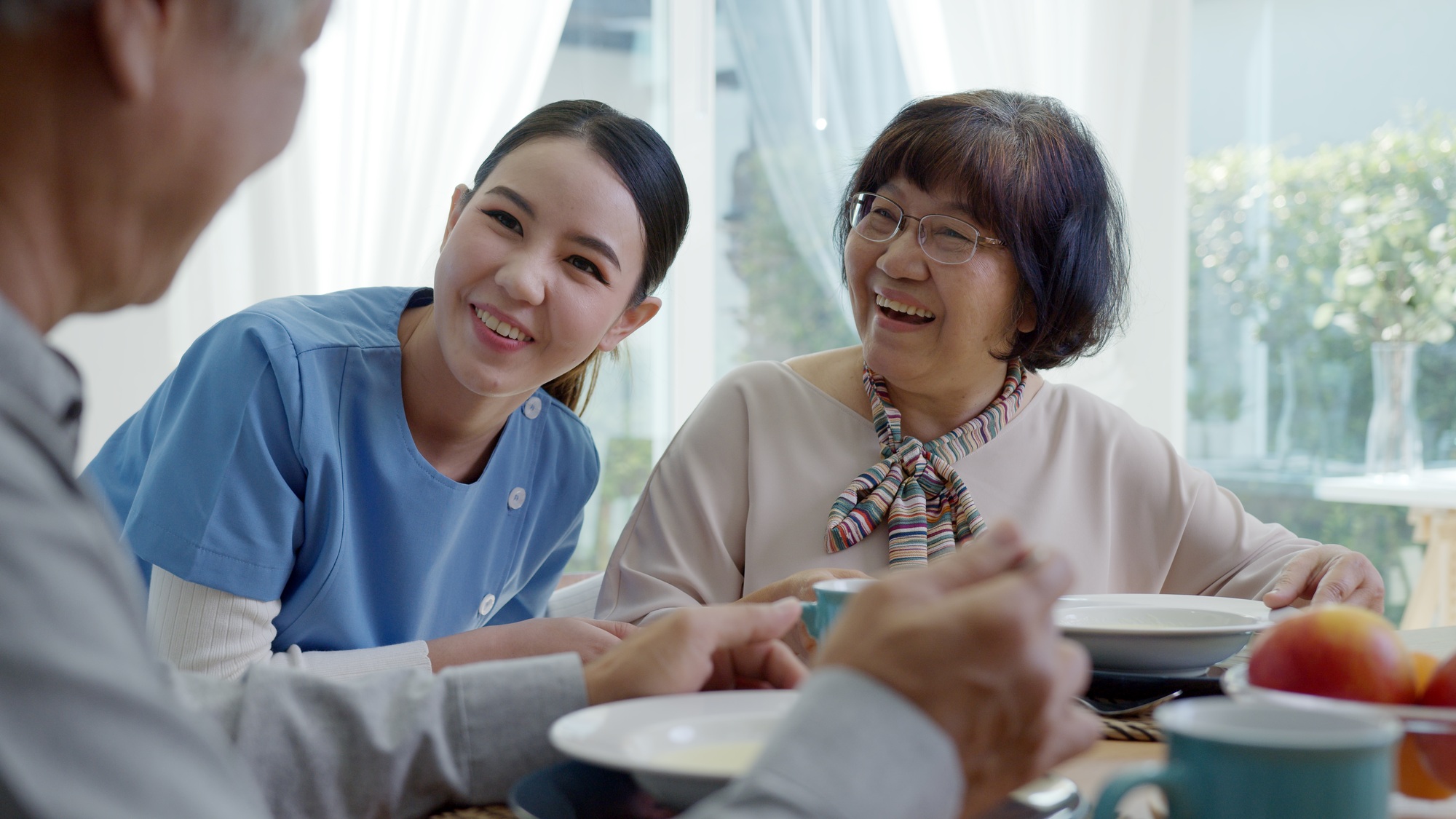 Attractive young senior asian citizen couple happy sit, talk, eat soup for healthy nutrition